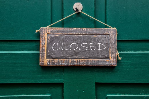 Skylt med texten closed mot grön ytterdörr