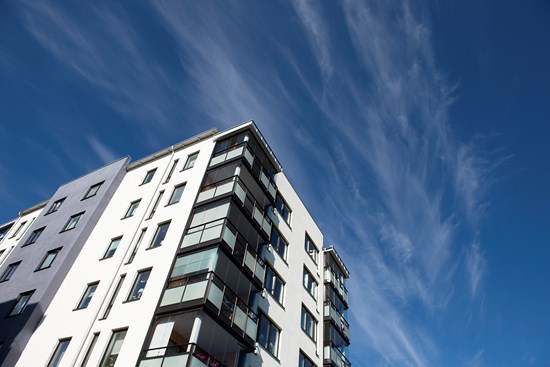 Svartvitt flerbostadshus med blå himmel som bakgrund